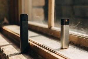 Simplicity of Disposable Vape vs. Pod System A simple, one-piece Raz Vape next to a multi-part JUUL system with its separate charger and pods